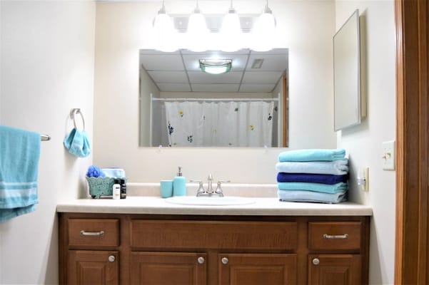 Well-lit bathroom with towels and toiletries
