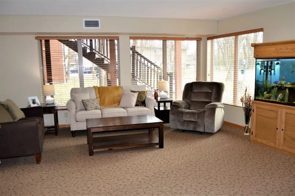 A living room with comfortable seating and large windows.