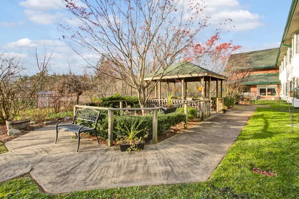 A peaceful garden area with a gazebo and bench
