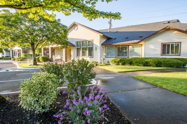 Exterior view of a senior living facility with garden