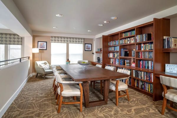 Cozy common area with bookshelves and a communal table