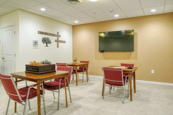 Interior activity room with tables and chess set