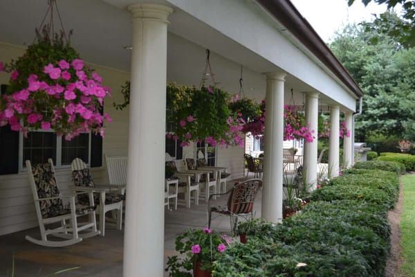 Outdoor seating area with hanging flowers and greenery