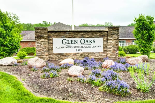 Sign of Glen Oaks Alzheimer's Special Care Center surrounded by flowers and greenery