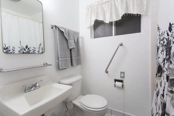 Bright bathroom with sink, toilet, and towel rack