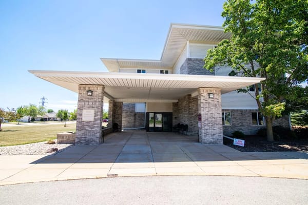 Front entrance of Glenwood Senior Apartments with trees and blue sky