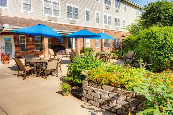 Outdoor patio with seating and umbrellas in a garden
