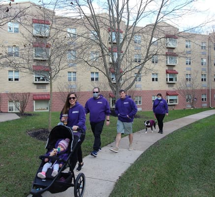 Residents and staff walking together outside the facility