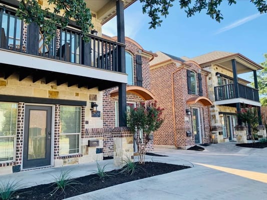 Exterior of Go Giver Assisted Living facility showing balconies and landscaped entrance