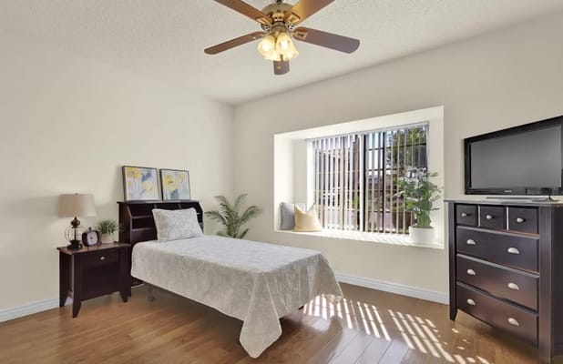 Bright private resident room with a bed and window