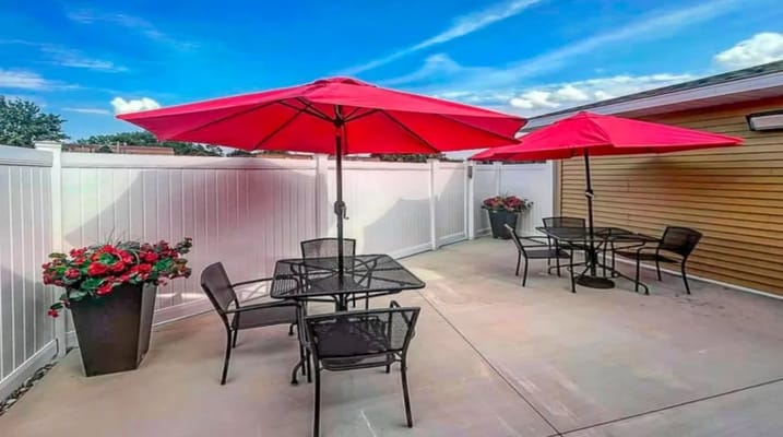 Outdoor patio with red umbrellas and flower pots