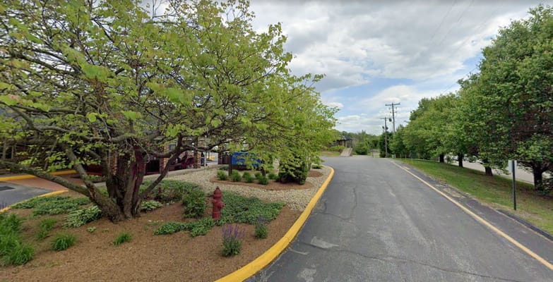 Entrance view of Golden Living Center with trees and landscaping