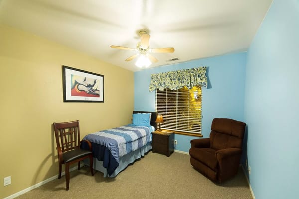 Private resident room with a bed and chair