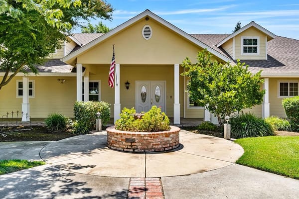 Main entrance of Grace Gardens Senior Care with a landscaped pathway and American flag.