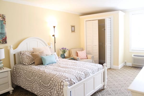 A cozy resident room with a bed and seating area