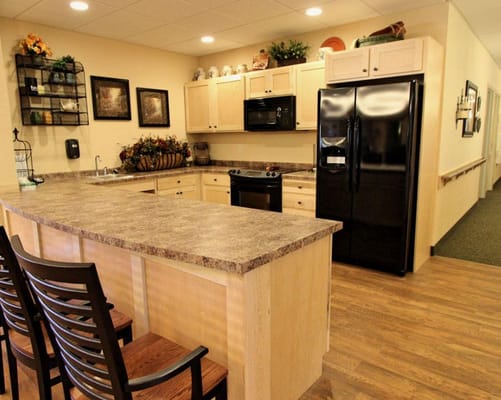 Bright kitchen with wooden cabinetry and appliances