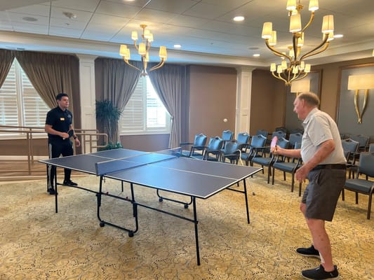 Two individuals playing table tennis in a recreation room