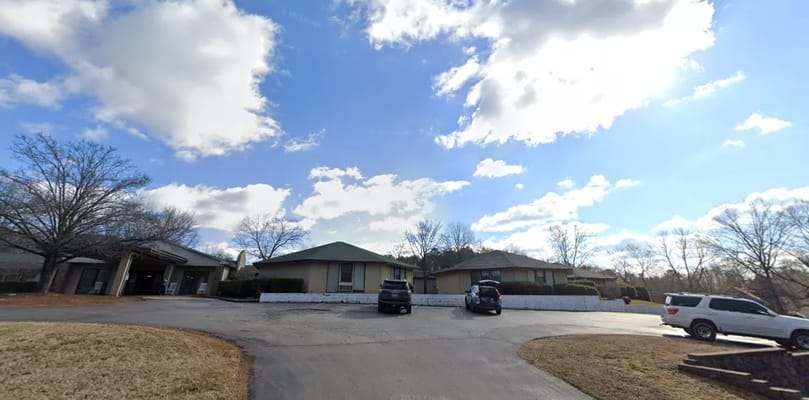 Exterior view of Grand Villa Assisted Living facility with cars parked nearby