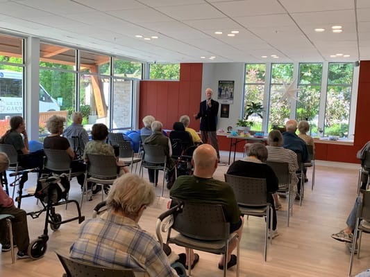 Residents attending a presentation in a bright activity room