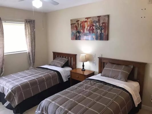 A cozy bedroom with two twin beds and a bedside lamp