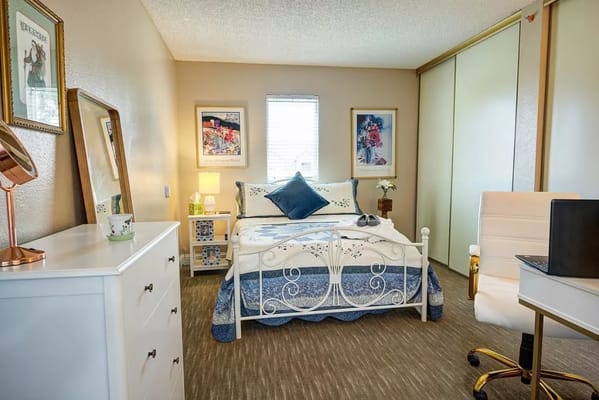 Bedroom with a bed, desk, and decorative art