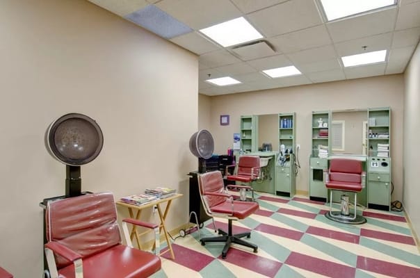 Hair salon area with styling chairs and dryers