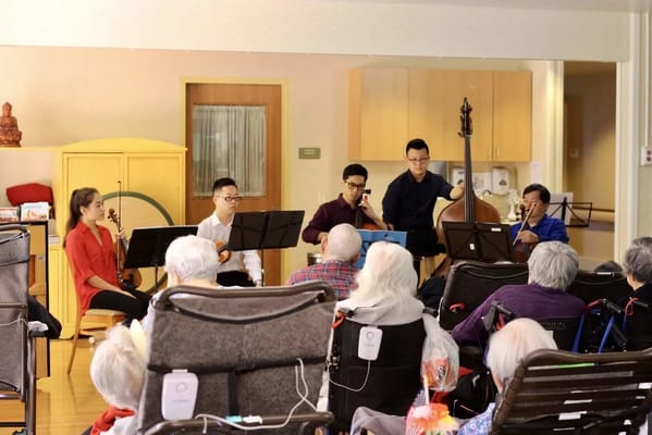 Residents enjoying a musical performance in a common area