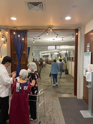 Two elderly residents conversing with a staff member at Hale Ola Kino.