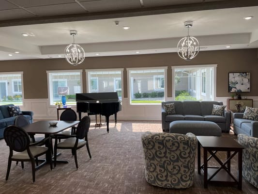 Bright common area with seating and a piano
