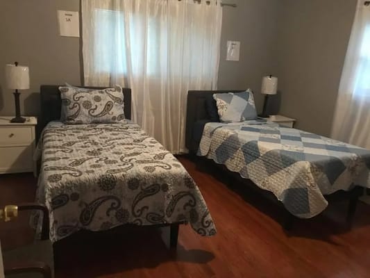 Two twin beds in a shared room with warm lighting