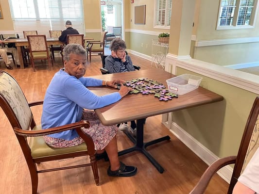 Residents working on a puzzle in a common area