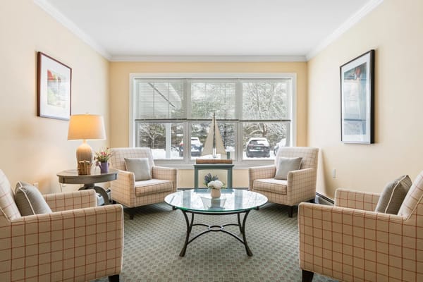 Comfortable sitting area with two chairs and a coffee table by large windows
