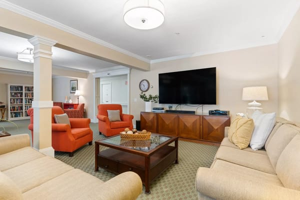 Cozy living room with orange chairs and a large TV