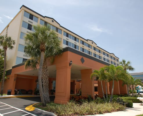Front view of Harborside at Melbourne with palm trees and colorful landscaping