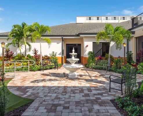 Courtyard featuring a fountain surrounded by tropical plants
