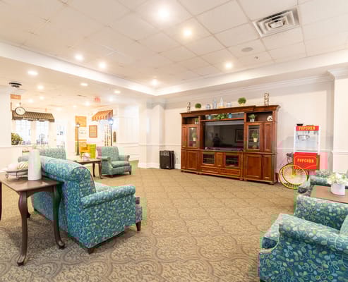 Spacious common area with teal seating and entertainment center