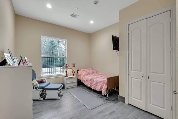 A private resident room with a bed and wheelchair