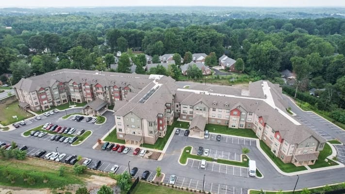 Aerial view of Harmony at Greensboro senior living facility with landscaped grounds and parking area.