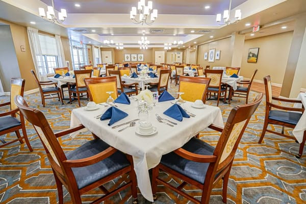 Elegant dining room set for a meal with blue napkins