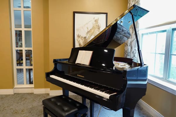 A grand piano in a well-lit common area.
