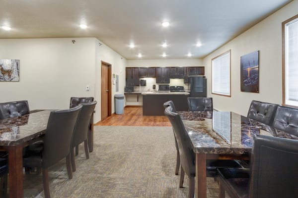 Interior common area with dining tables and kitchen in background