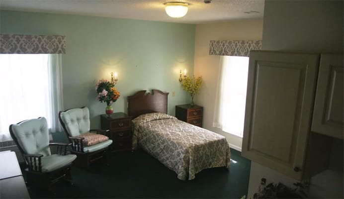 Cozy resident room with a bed and two chairs