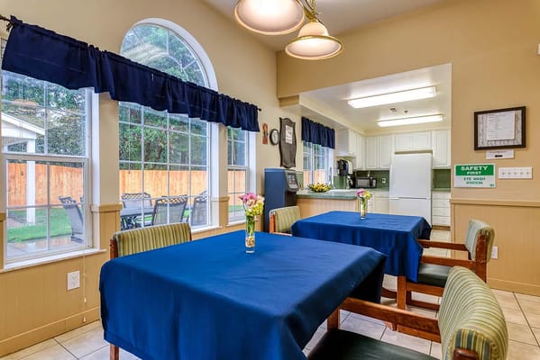 Bright dining area with blue tablecloths and large windows