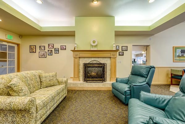 Comfortable seating area with a fireplace in a memory care facility