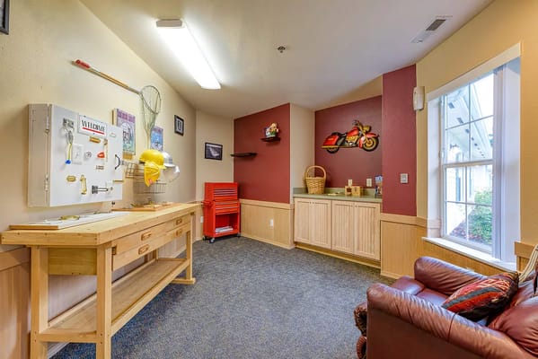 Interior view of an activity room with a workbench and colorful decor.