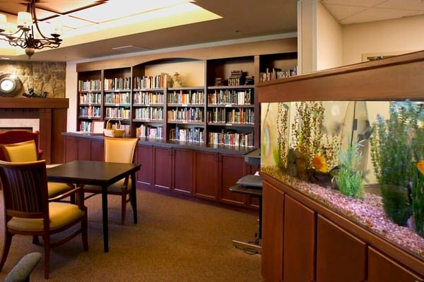 Interior view of a cozy library with books and an aquarium