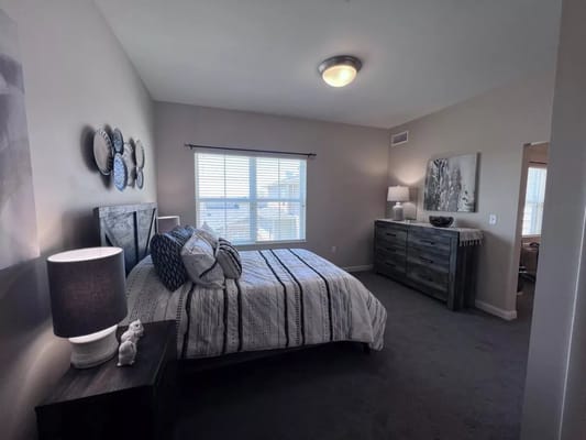 A well-furnished private resident room with a bed and window