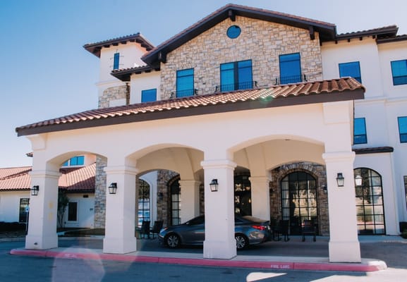 Exterior view of a senior living facility with a stone facade
