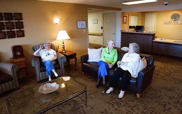 Three senior women sitting together in a cozy lounge area
