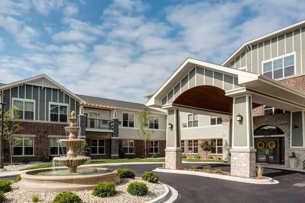 Exterior view of a senior living facility with a fountain